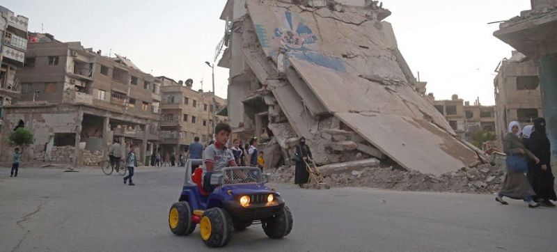 a-child-rides-a-toy-car-as-people-celebrate-eid-al-fitr-in-east-ghouta-syria-49e0940ad385136a7bc21bc93cd7a7b31656436576.jpg
