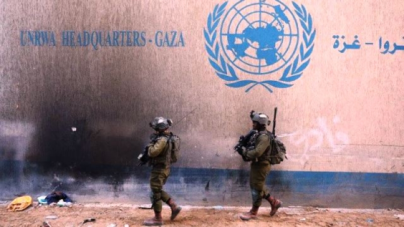 israeli-soldiers-pass-by-an-unrwa-building-in-gaza-1e601d5c12ee13959c6e468839c5b5f41740593795.jpg