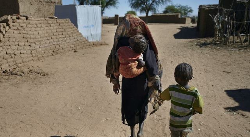 a-mother-walks-with-her-children-to-their-shelter-at-an-idp-camp-in-north-darfur-55e96dc8a5a476ff566fade85b6c3ec71743137927.jpg