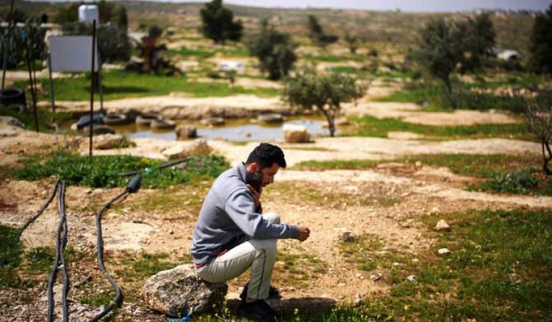 basel-adra-one-of-the-directors-of-the-oscar-winner-documentary-no-other-land-speaks-on-the-phone-as-he-sits-in-an-area-near-the-house-of-palestinian-co-director-hamdan-ballal-2f1a0f171eafb33aa1caa55f010c433e1757819827.jpg