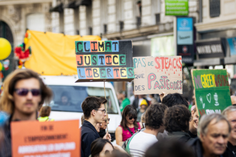 a-protestor-holds-a-placard-that-says-climate-justice-freedoms-during-the-march-of-resistance-to-denounce-climate-inaction-7f0bddef047a378fa082d56c1872689a1761328988.png