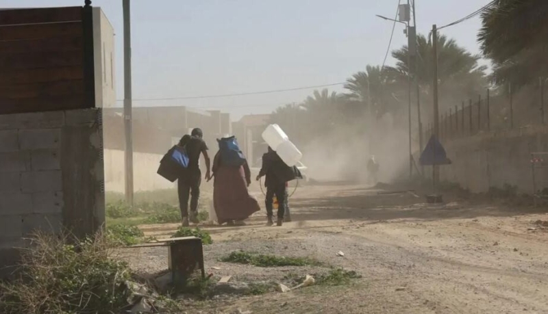 people-walk-down-a-dusty-road-in-the-west-bank-carrying-belongings-6fcf6664e8bec7fc586feb2e27e44ca11788543715.jpg