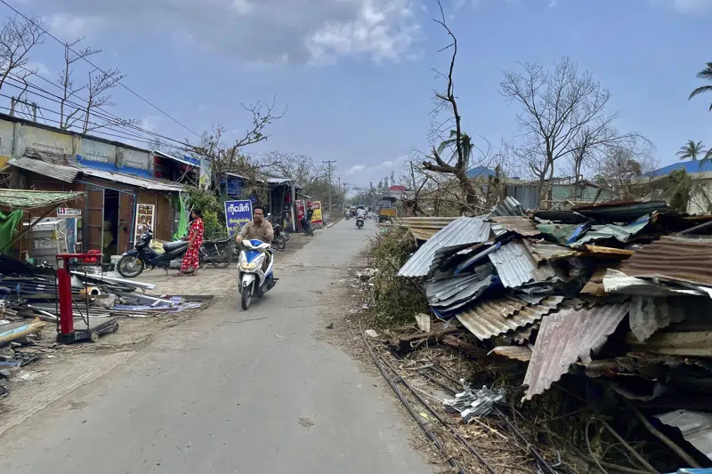 local-people-ride-motorbike-along-a-roadside-with-damaged-buildings-after-cyclone-mocha-in-sittwe-township-rakhine-state-myanmar-friday-may-19-2023-dd5d22c8ed1c65313858a4b6de6522601684517666.png