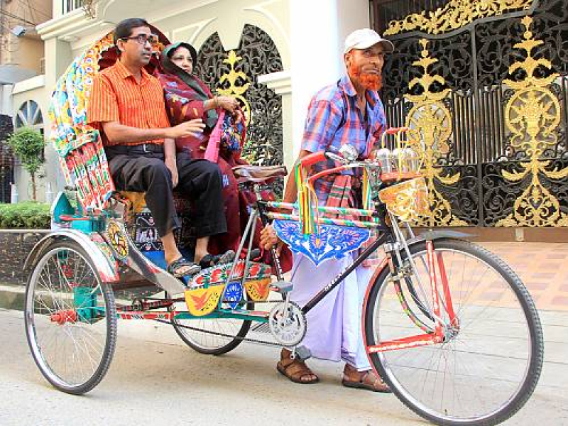 a-rickshaw-puller-starts-a-trip-in-his-tricycle-decorated-with-paintings-on-a-street-in-dhaka-the-capital-of-bangladesh-49ef68a3a26d33a6e28130556b30ee861701880335.jpg