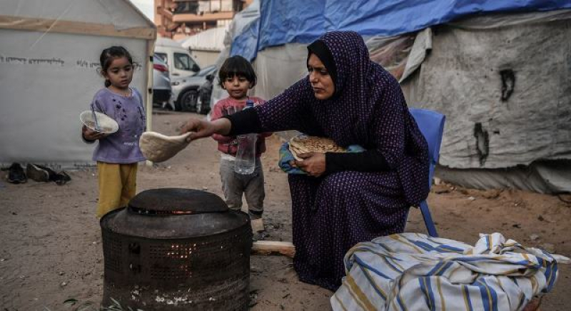 a-mother-prepares-a-meal-for-her-children-outside-their-makeshift-home-in-a-refugee-camp-in-khan-younis-gaza-22117b0cc3841019a8e59ebff669b32f1710786713.jpg