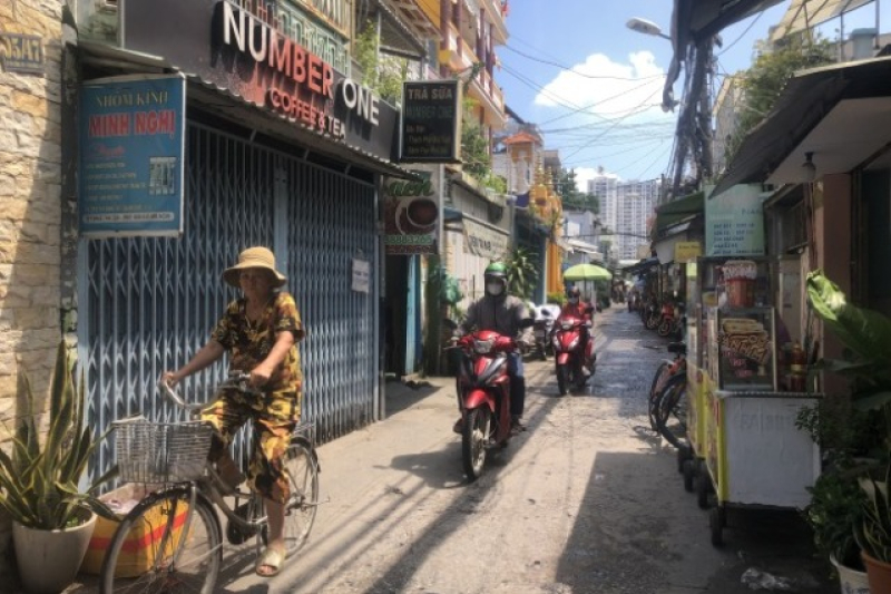 one-of-many-small-streets-in-ho-chi-minh-city-with-newly-build-towers-in-the-background-ac2141544970d7a19593454ed49901a61712387613.jpg