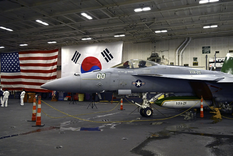 an-f-18-fighter-aircraft-sits-in-the-hanger-of-aircraft-carrier-theodore-roosevelt-cvn-71-anchored-in-busan-naval-base-south-korea-saturday-june-22-2024-4e50a3efa8b3e334be9d3e011dc1cf581719118627.png