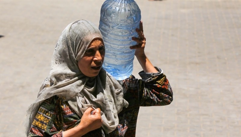 a-woman-carries-a-bottle-of-drinking-water-amid-a-heatwave-in-deir-al-balah-middle-area-the-gaza-strip-132b37f0a39bfcca7fff25842e9827cd1720809275.jpg