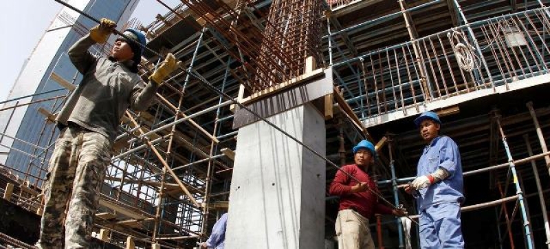 migrant-workers-transport-metal-rods-on-a-construction-site-in-qatar-file-d97fa1fca4aeba26f540ff8e13bef95b1734428647.jpg